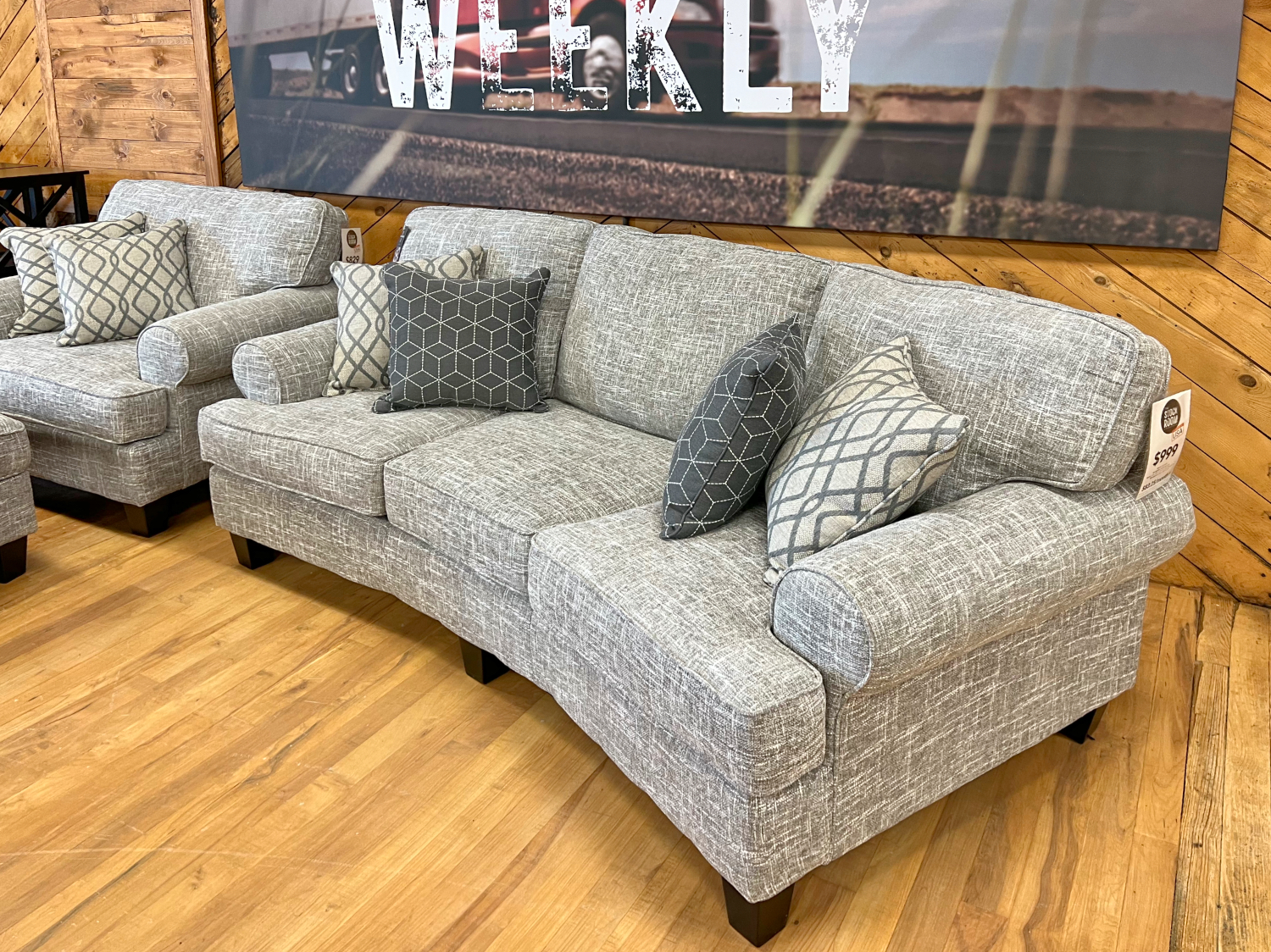 curved sofa in grey fabric in the stock room discount furniture warehouse in rockford, il