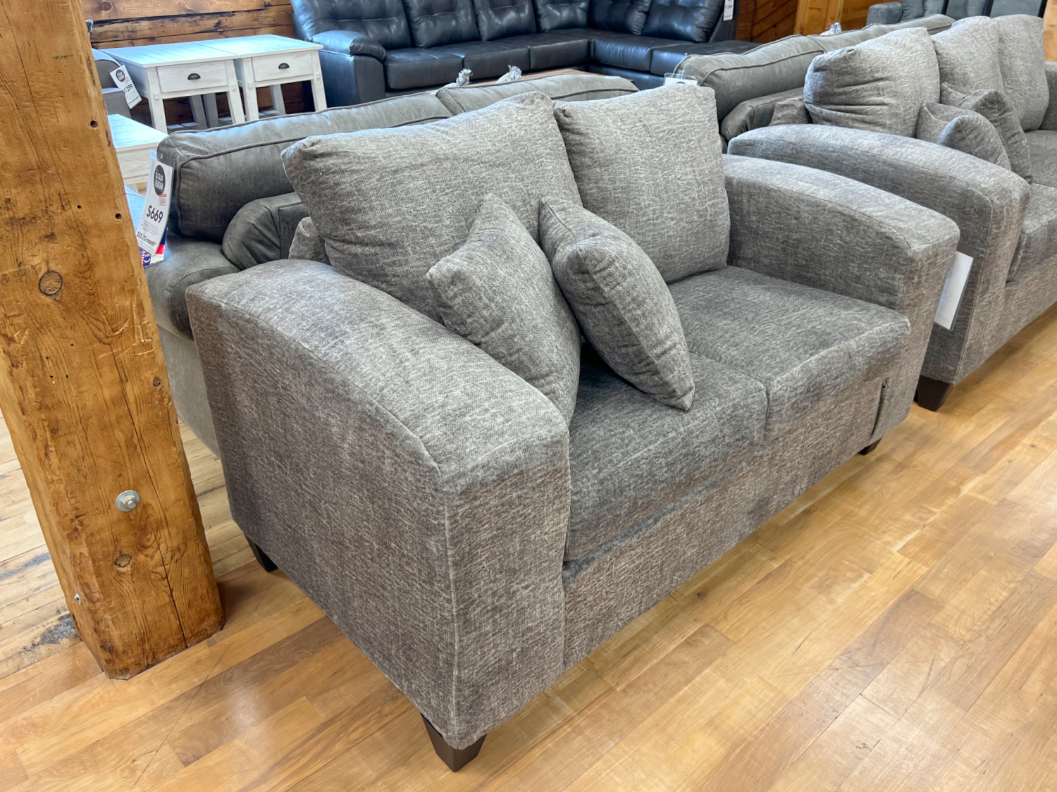 plush loveseat with wide arms in a cozy taupe fabric in the stock room discount furniture warehouse in rockford, il