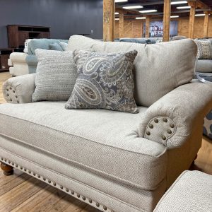 beige farmhouse chair and a half with nailhead trim in the stock room discount furniture warehouse in rockford, il