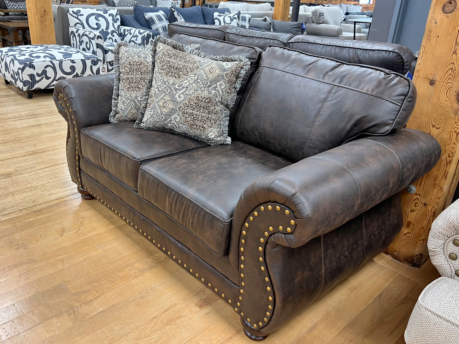 traditional lodge style leather-look loveseat in the stock room discount furniture warehouse in rockford, il