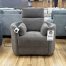 Modern charcoal brown textured fabric recliner chair with integrated side bolster pillows, displayed on a light hardwood floor at The Stock Room showroom.