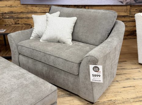 Tezza-6533 A contemporary oversized taupe fabric lounge armchair decorated with two patterned throw pillows.